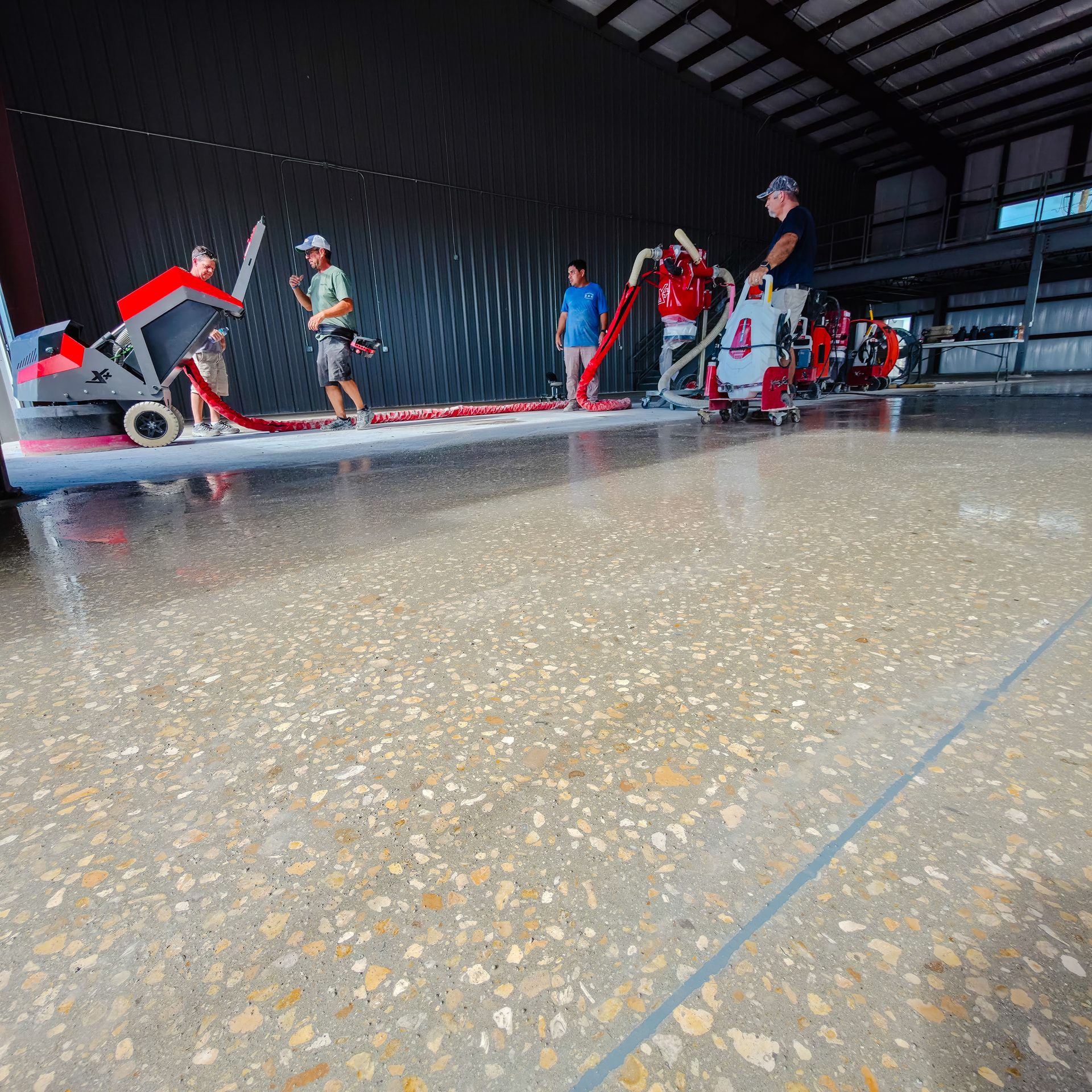 Exposed aggregate polished concrete with the Surface Masters crew in the background