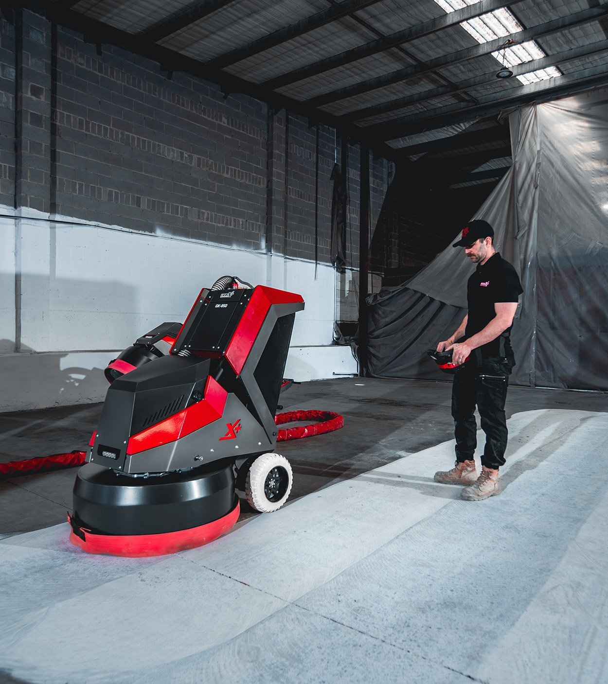 Operator running the WORX+ King Series via remote control on a commercial concrete slab