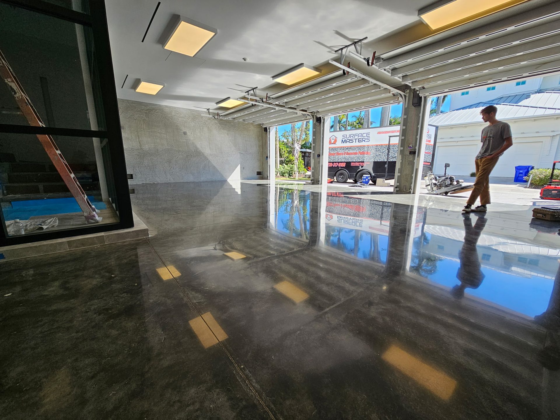 Wide view of polished concrete garage floor with Surface Masters trailer outside